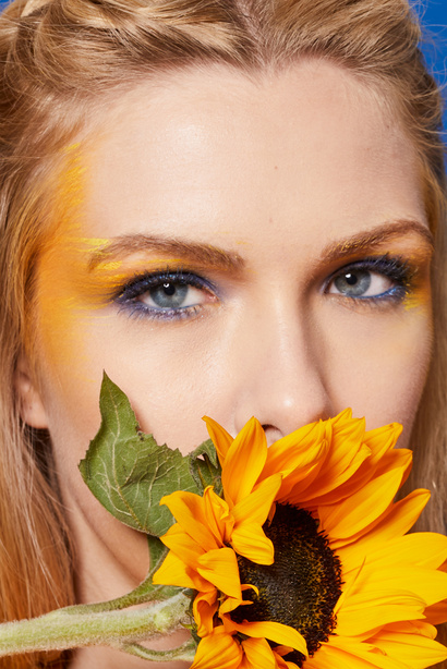 Woman with Yellow and Blue Eye Makeup with Sunflower