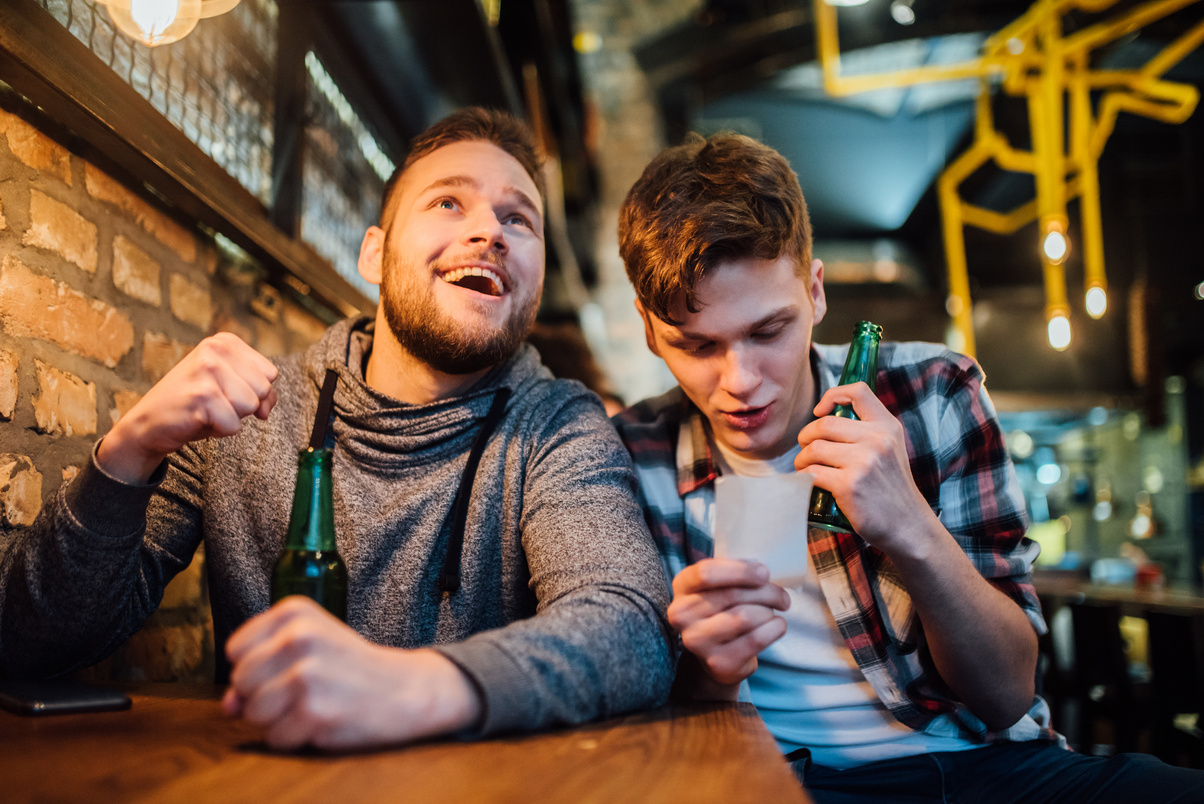 Men drinking beer and betting